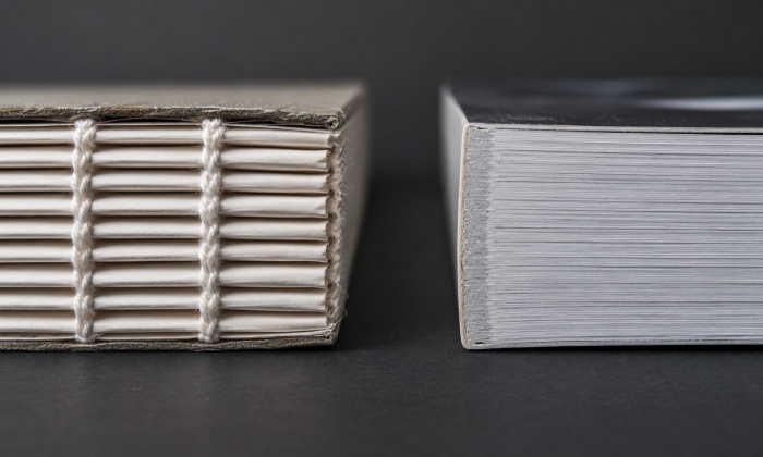 Close-up comparison of thread-sewn signatures and a perfect-bound spine